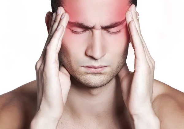 "Man holding his head in pain, experiencing a migraine, seeking relief through migraine home remedies.